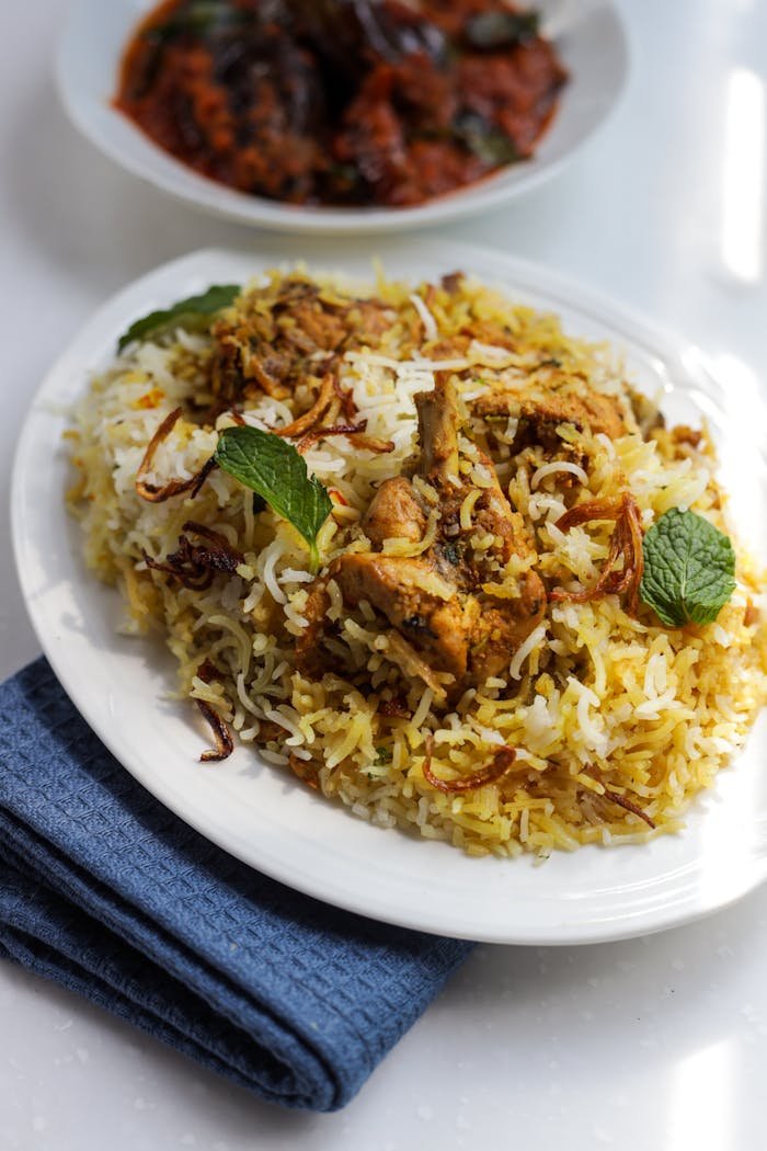 Close-up of flavorful chicken biryani garnished with mint leaves, perfect for a savory meal.